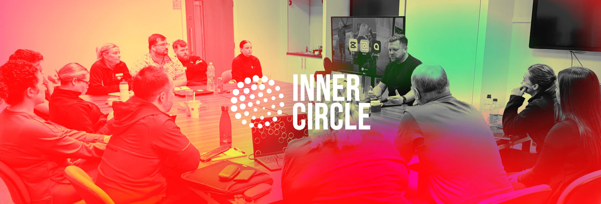 A workshop group seated around a table with laptops, with the Inner Circle logo